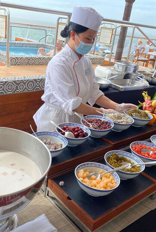 A station serving sweet coconut milk with several accompaniments, such as melon and beans. A station serving sweet coconut milk with several accompaniments, such as melon and beans.