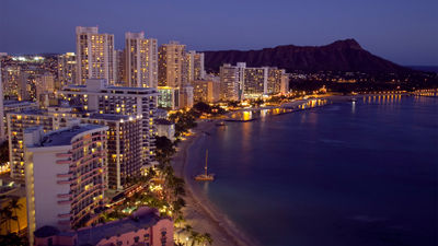 Honolulu at night. Occupancy improved but room rates dipped at Hawaii hotels in July, data shows.